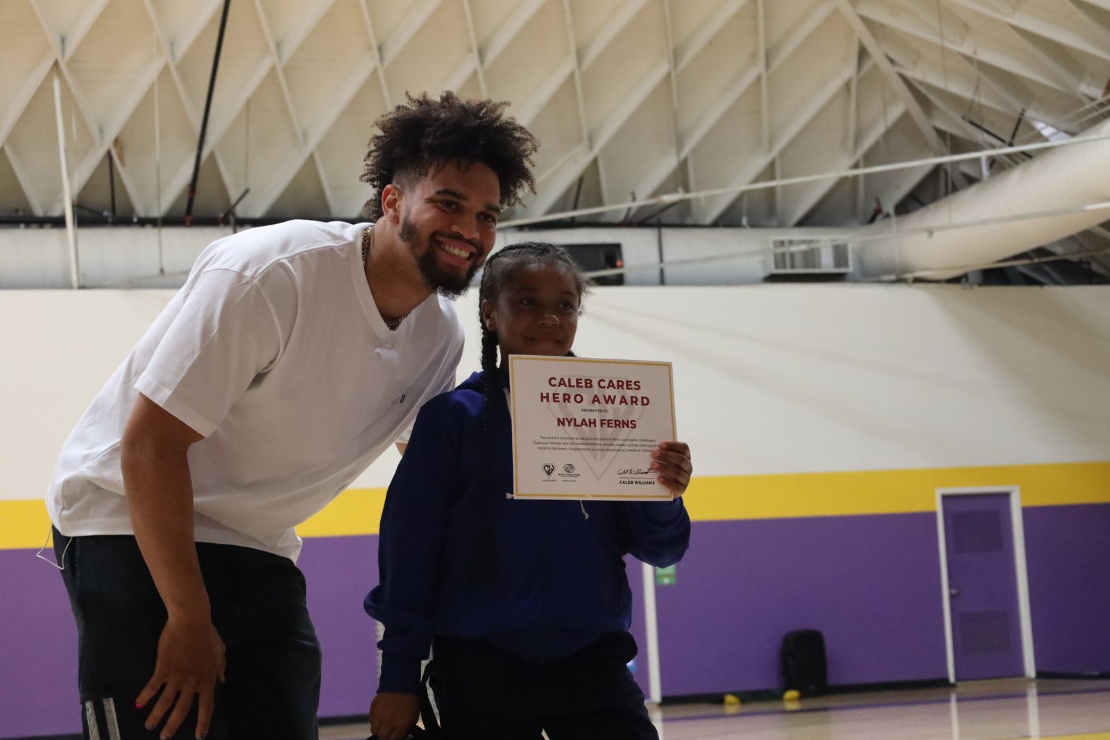 A student receiving her Caleb Cares Hero Award in the gym