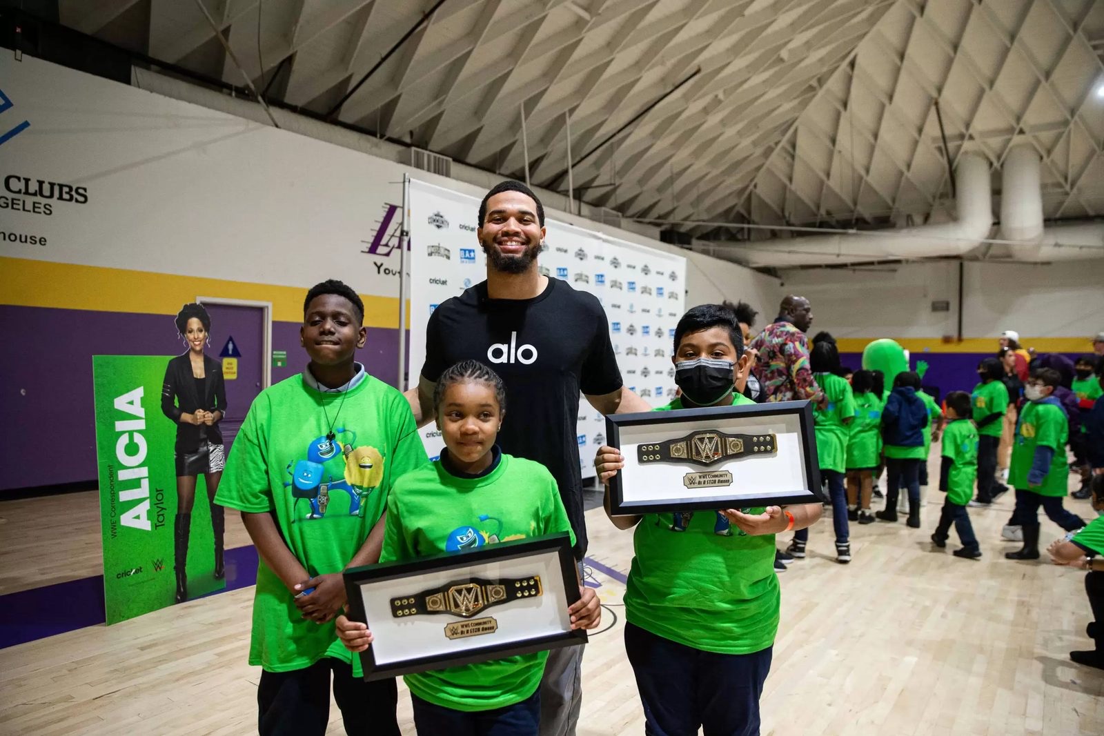 Students holding Caleb Cares Hero Award championship belts