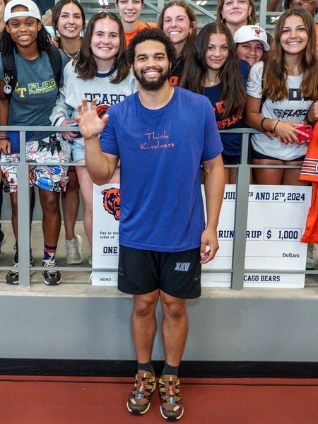 Caleb Williams waving in a Think Kindness shirt