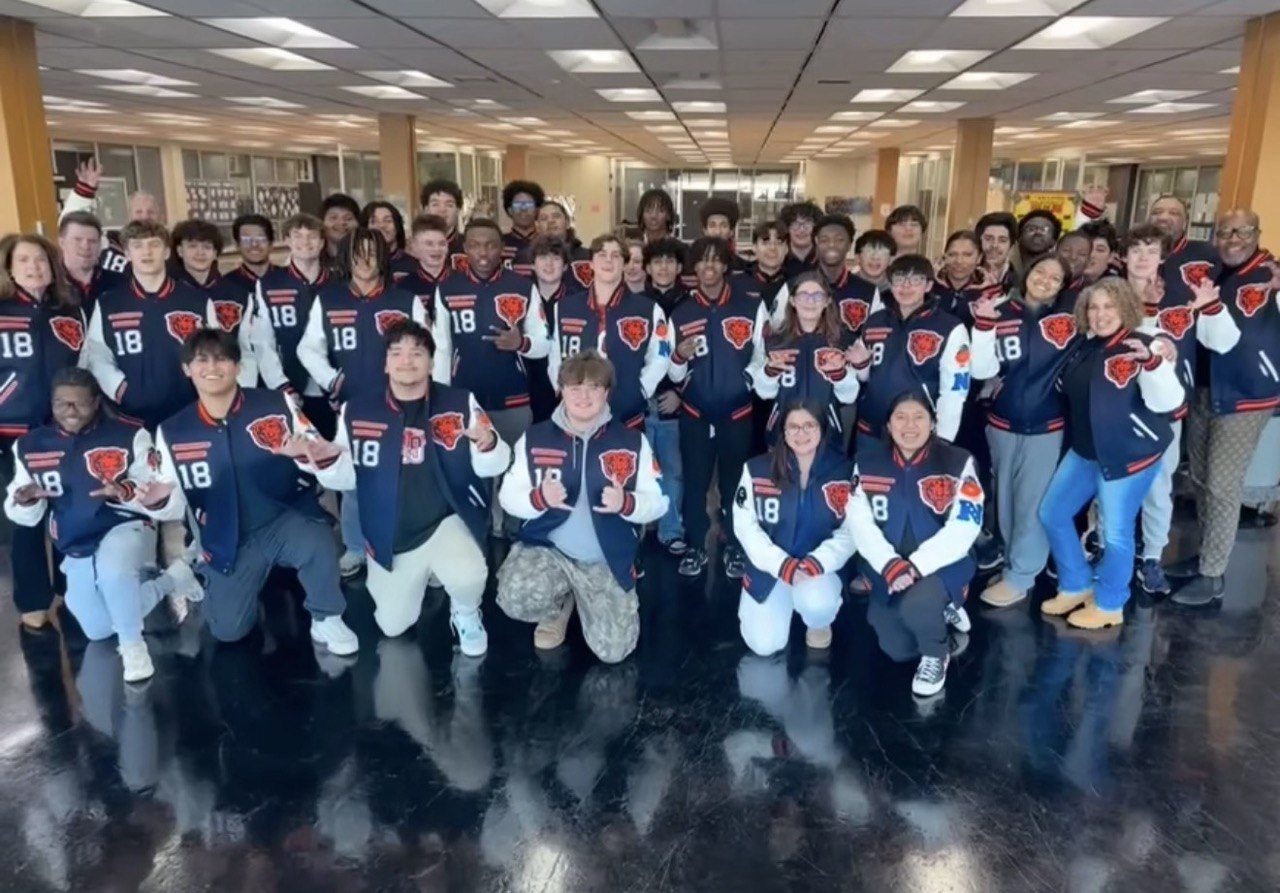 Group in matching varsity jackets celebrating together